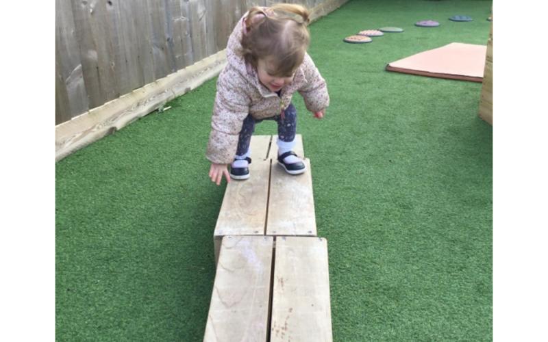 Child walking across planks