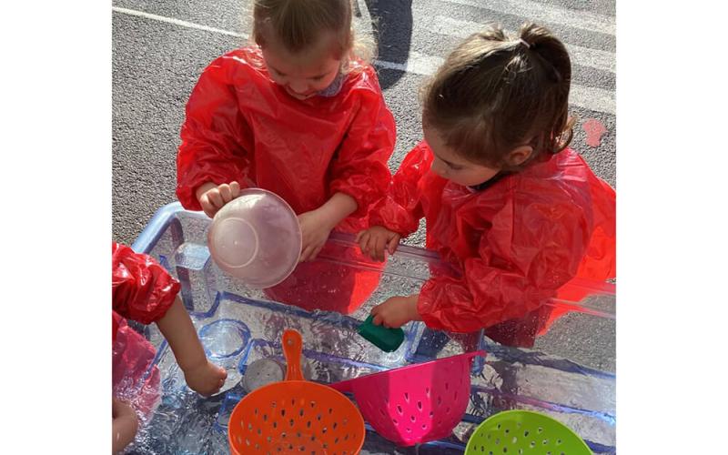 Children playing with bowls and colanders