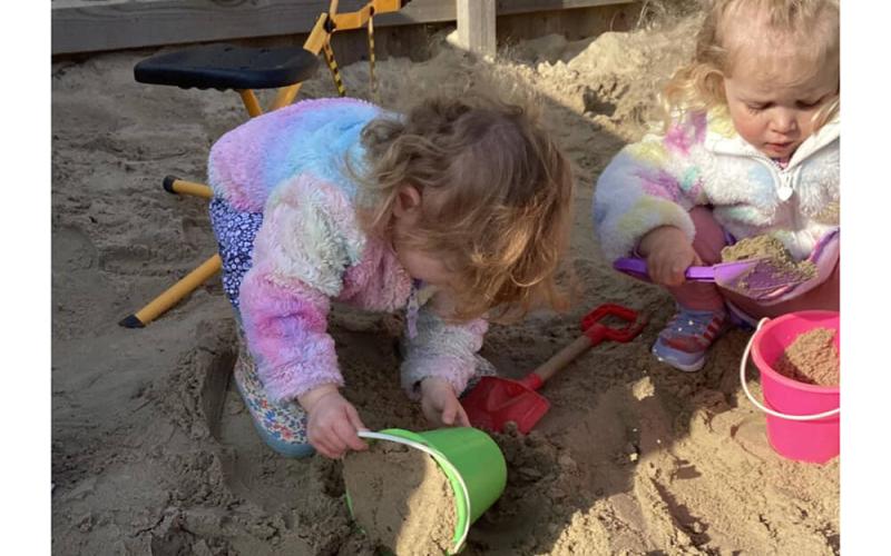 Children playing with sand and buckets