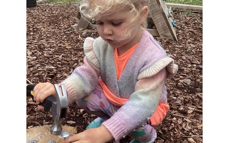 Child hammering nails into wood