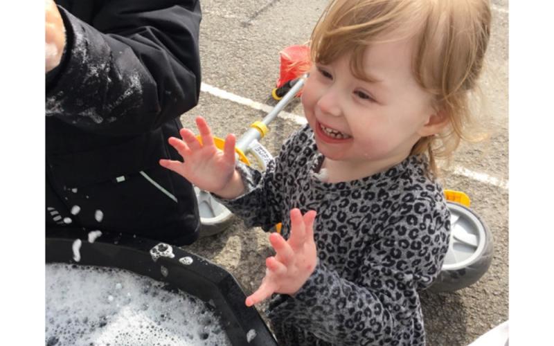 Child smiling in front of frothy water