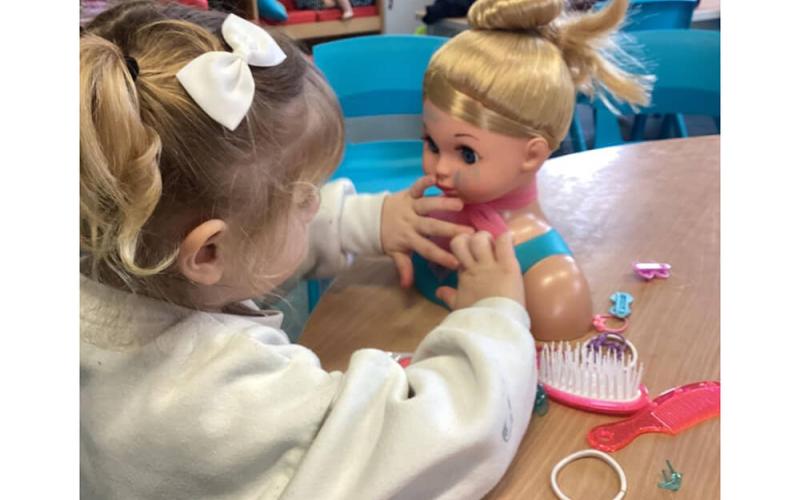Child decorating doll head